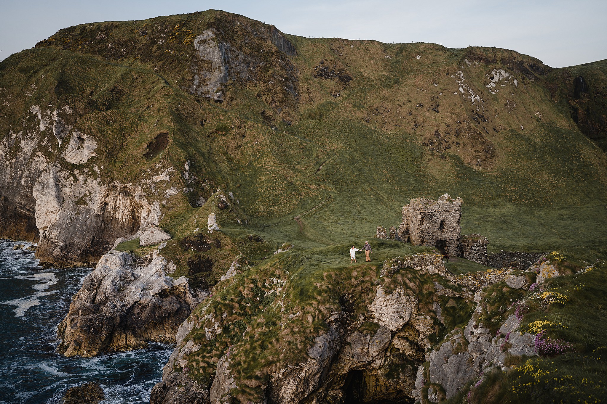 couple having engagement shoot at kinbane castle at sunrise