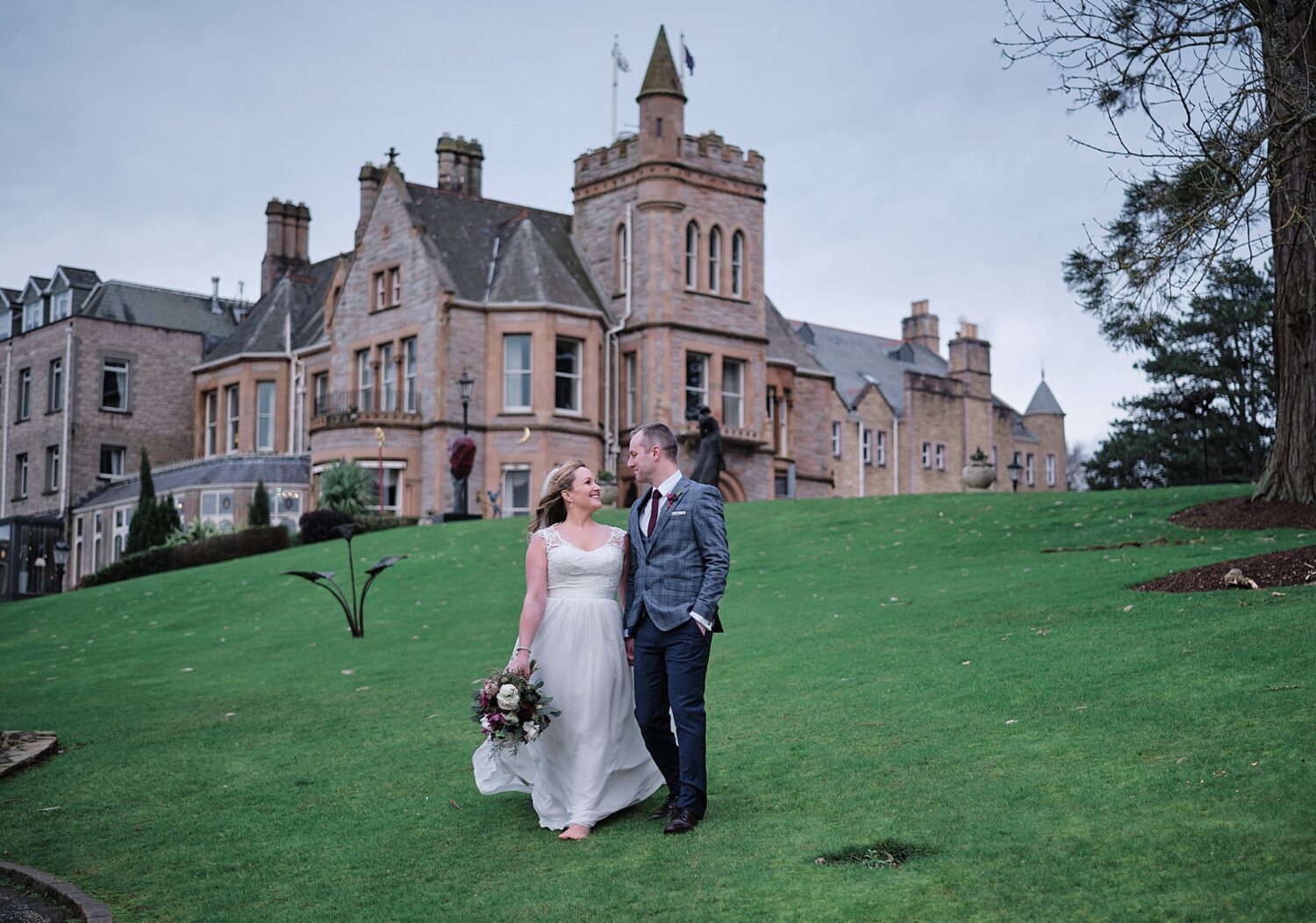 bride & groom walking on lawn in front of the Culloden