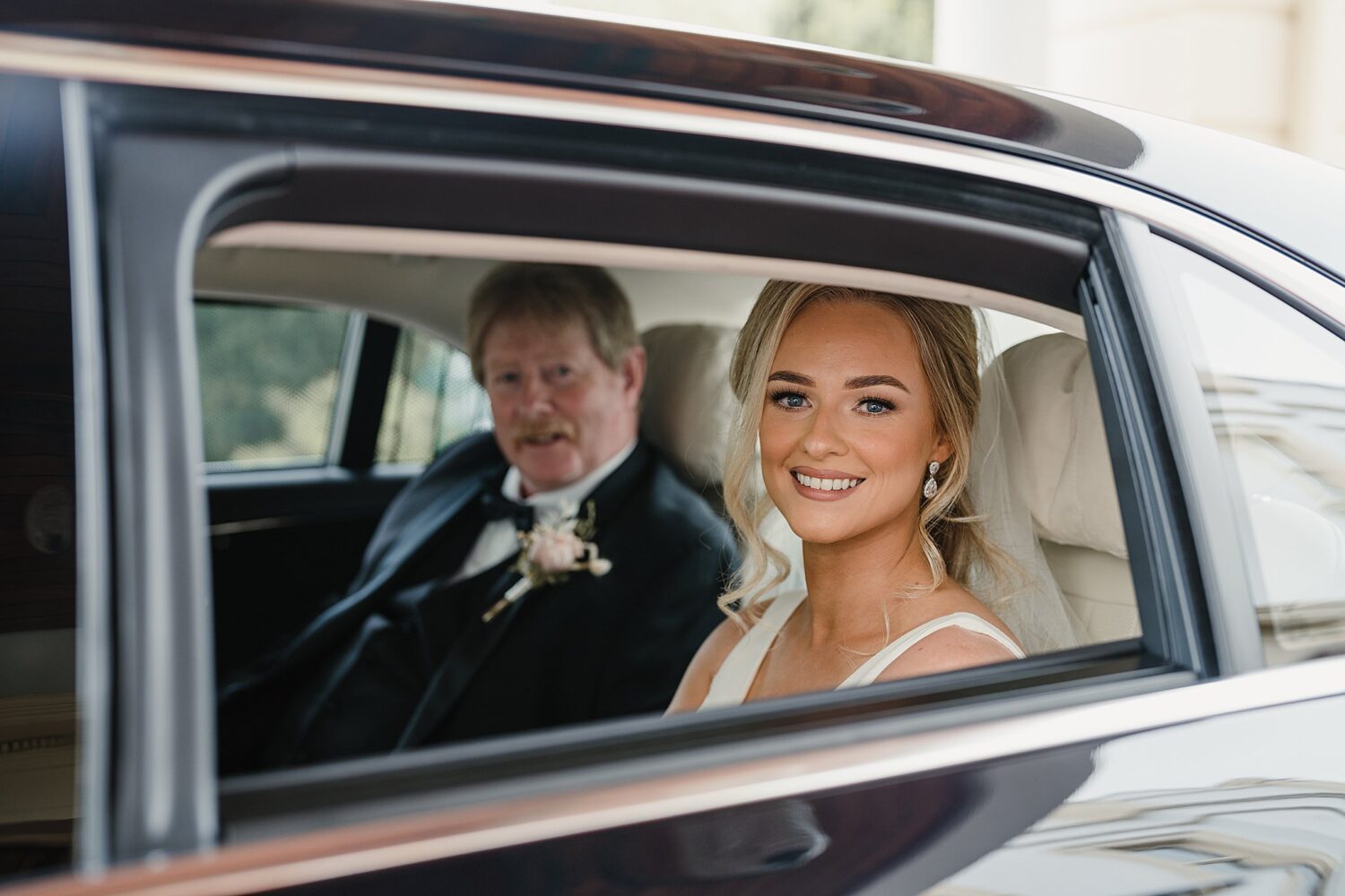 bride and father looking out of car window