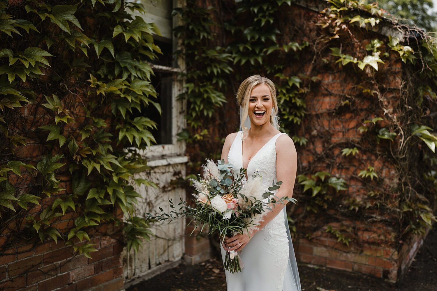 bride laughing during portraits at outdoor wedding at galgorm